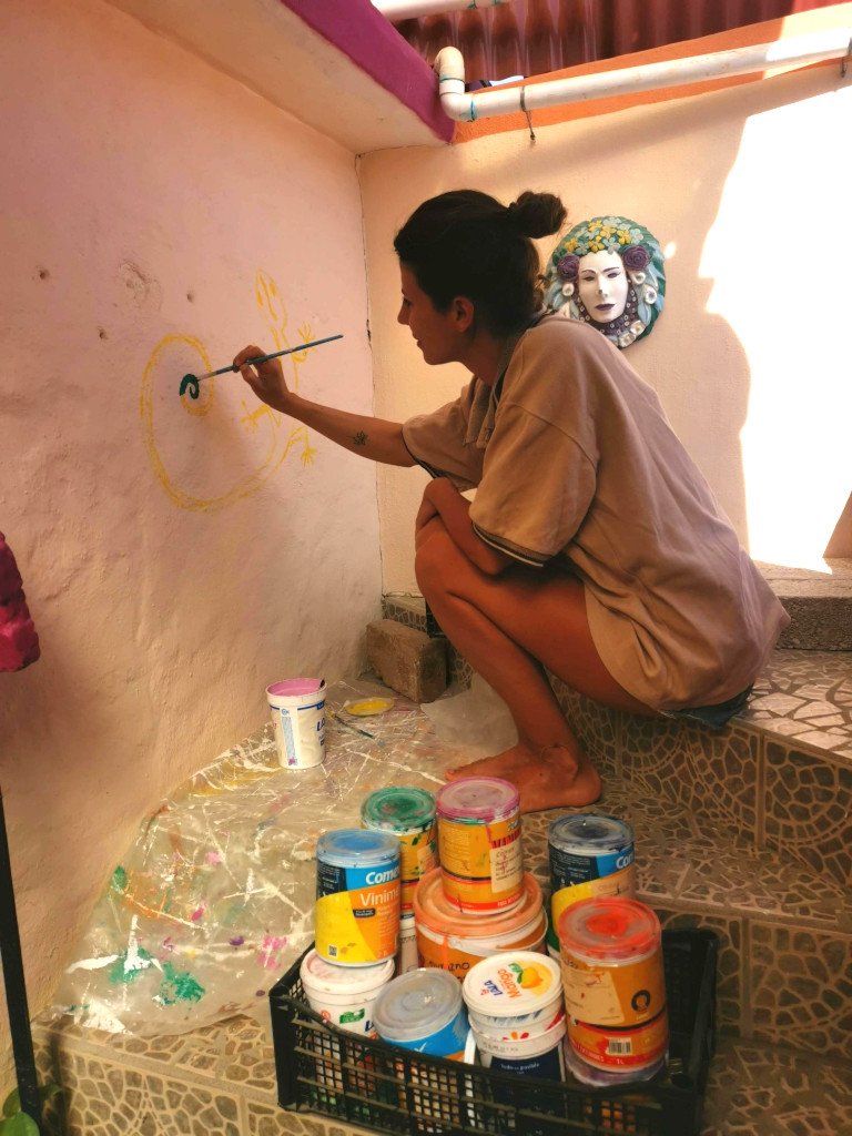 A woman painting a mural as part of her job on Workaway