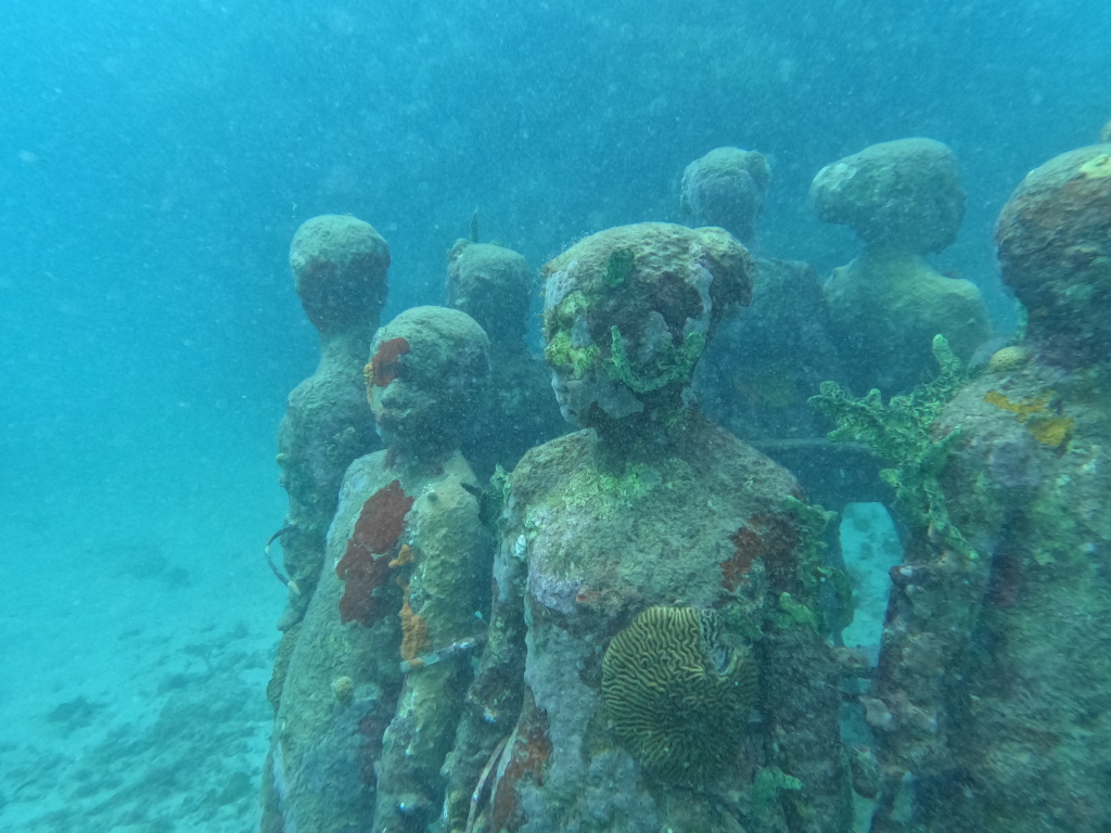 A ring of sculptures at the Grenada underwater sculpture park overgrown with corals