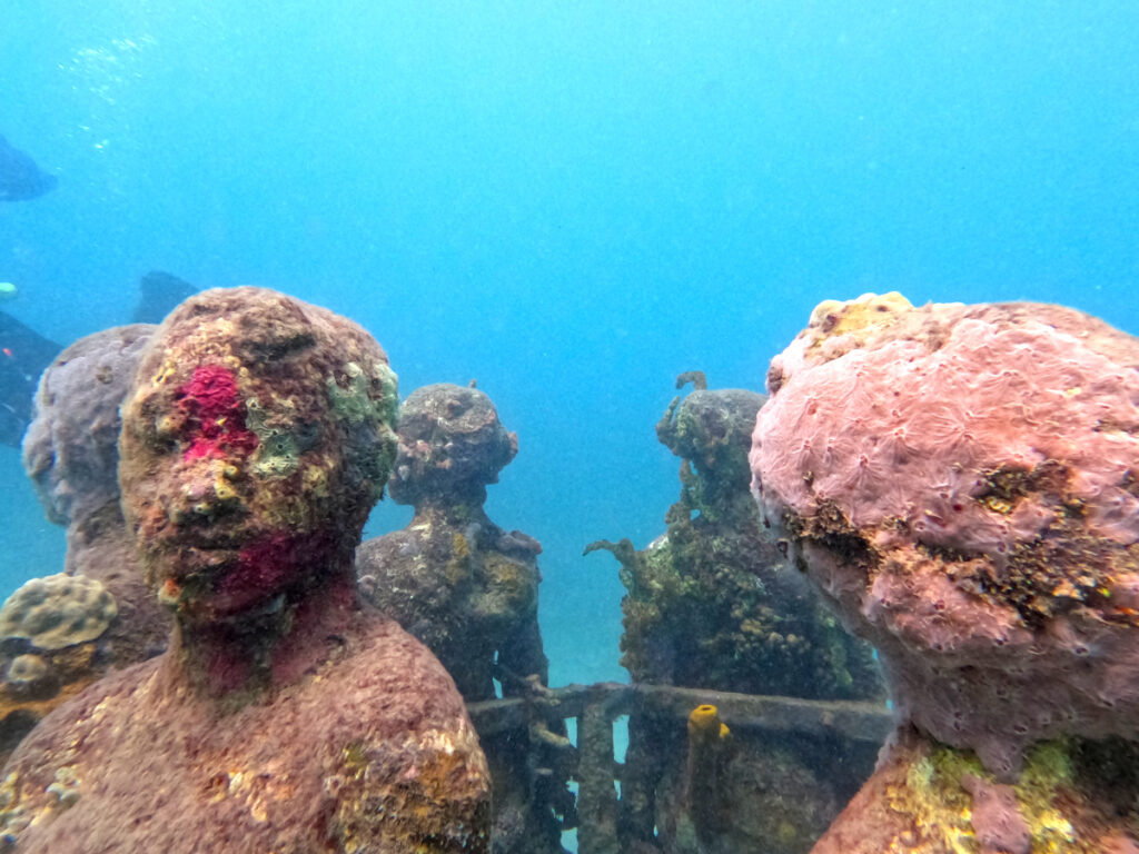 A ring of sculptures with coral growing on them at the grenada underwater sculpture park