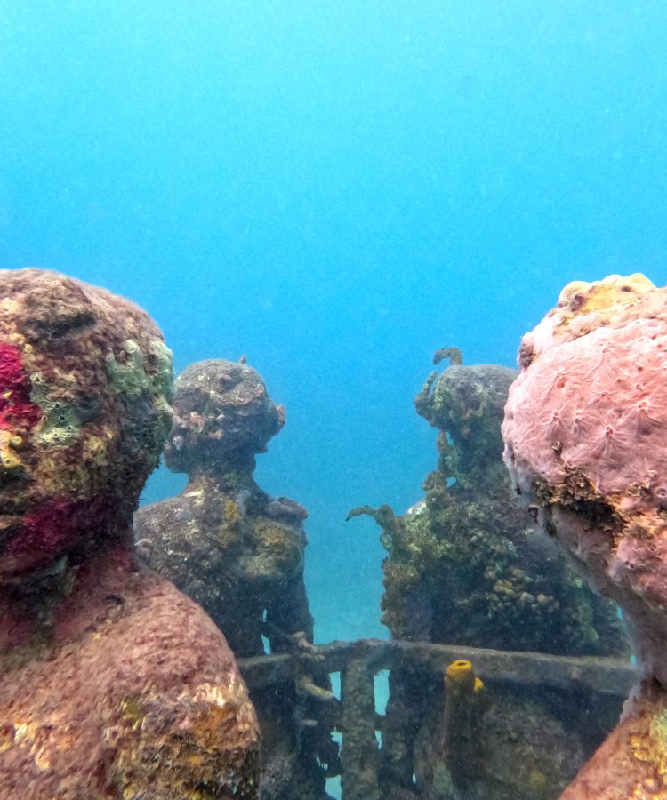 A ring of sculptures with coral growing on them at the grenada underwater sculpture park