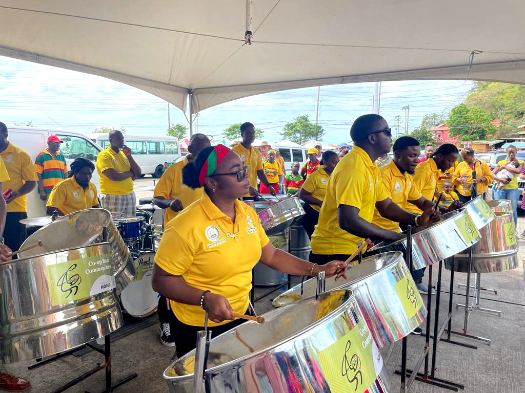 A steel drum group playing the drums all wearing yellow t-shirts on Independence Day in Grenada