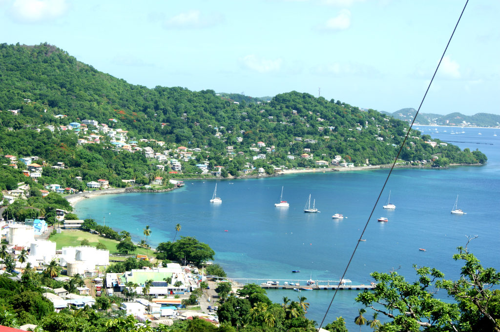A bay with clear blue water and green hills in the background on the west coast of Grenada