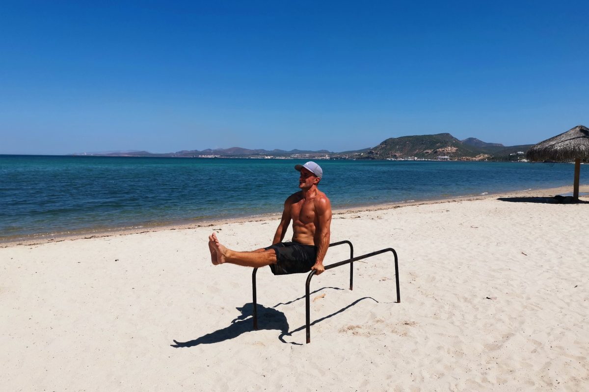 A man working out for free on the beach while traveling