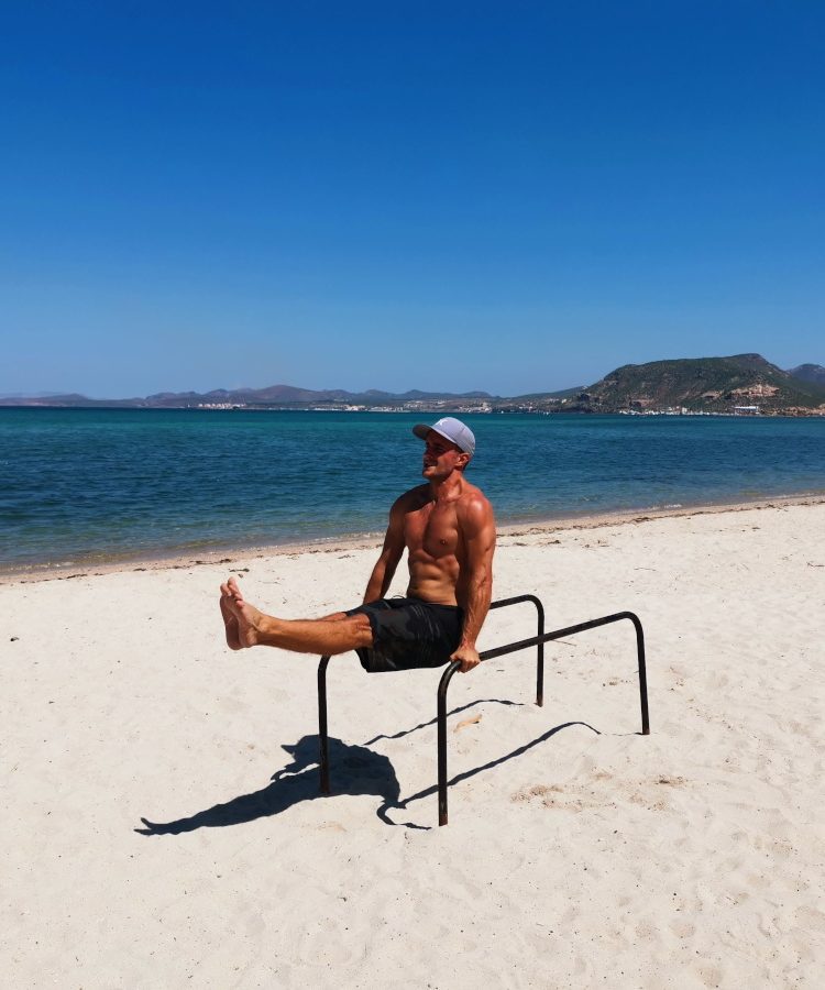 A man working out for free on the beach while traveling