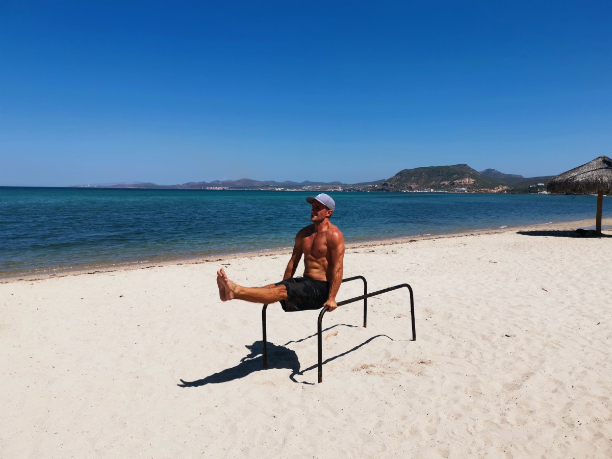 A man working out for free on the beach while traveling