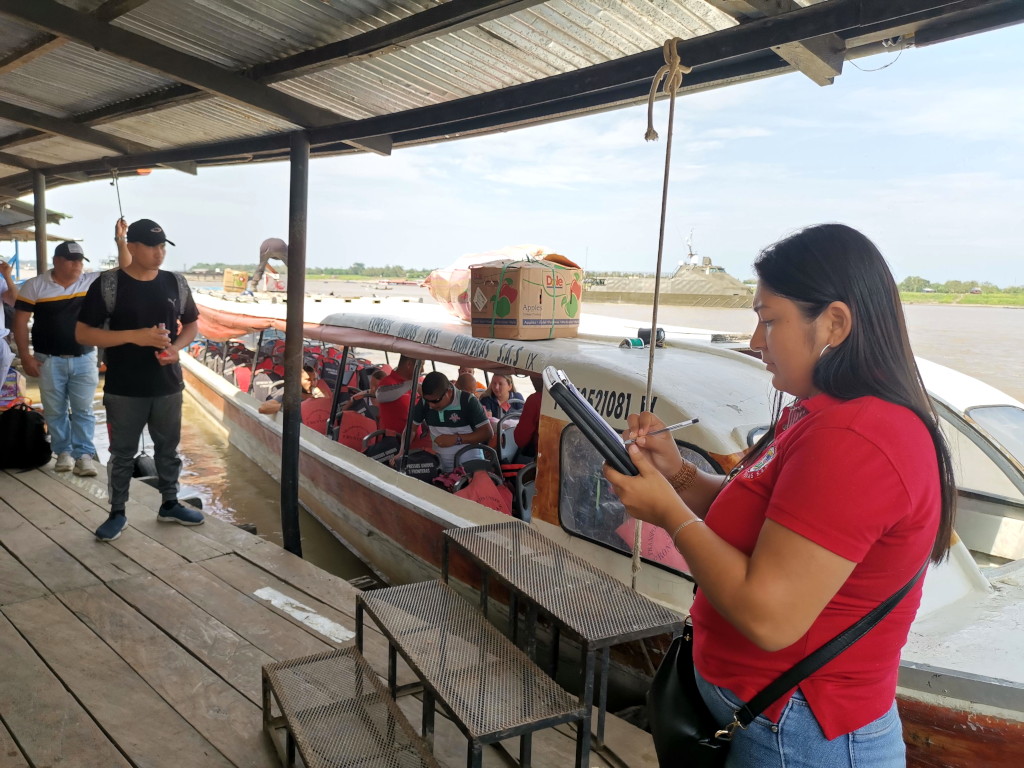 A woman in a red t shirt waiting to allow people onto a boat from Leticia to Puerto Narino