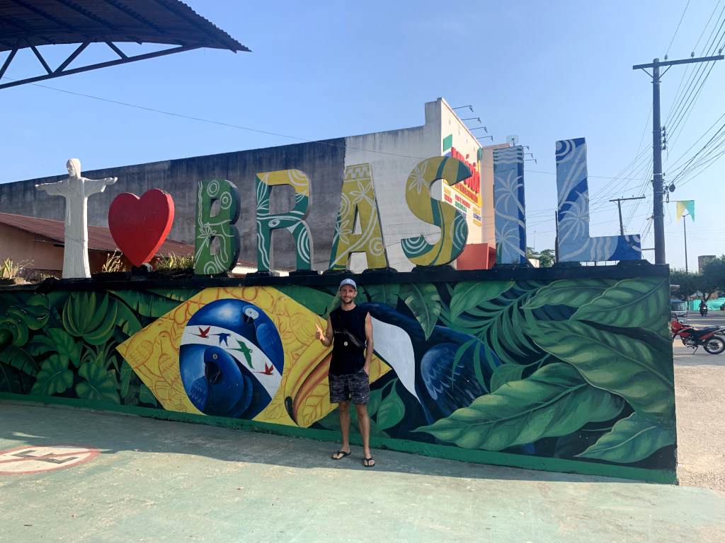 A man in a black singlet standing next to a sign which says I love Brasil
