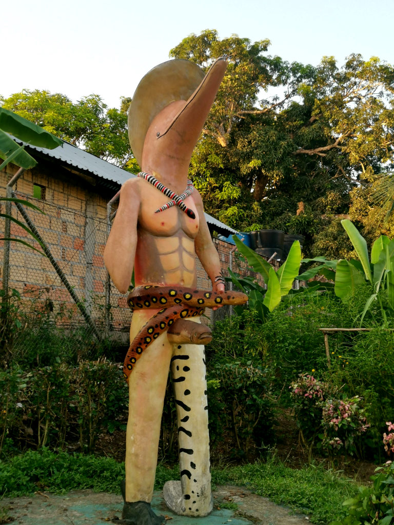A statue of a dolphin with other animal parts attached to it in a small town in Colombia