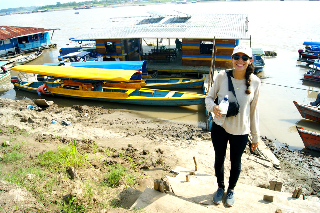 A woman standing in front of boats at the river bank in Leticia