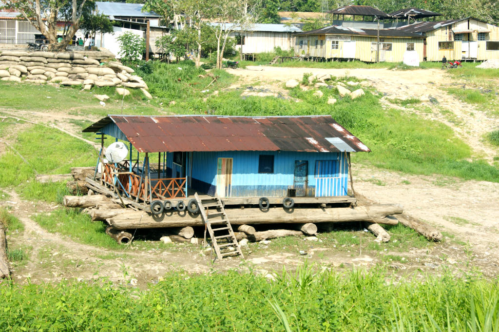A house boat sitting on dry land in the Amazon because it is the dry season