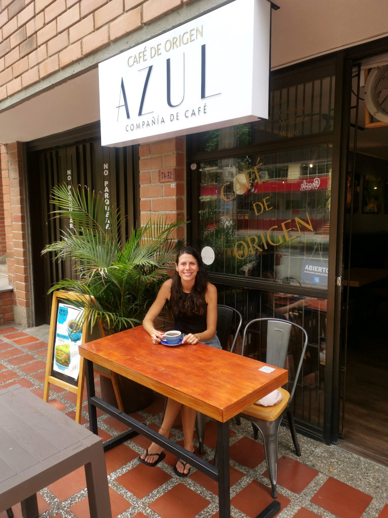 A woman sitting on a table outside Azul Cafe Laureles