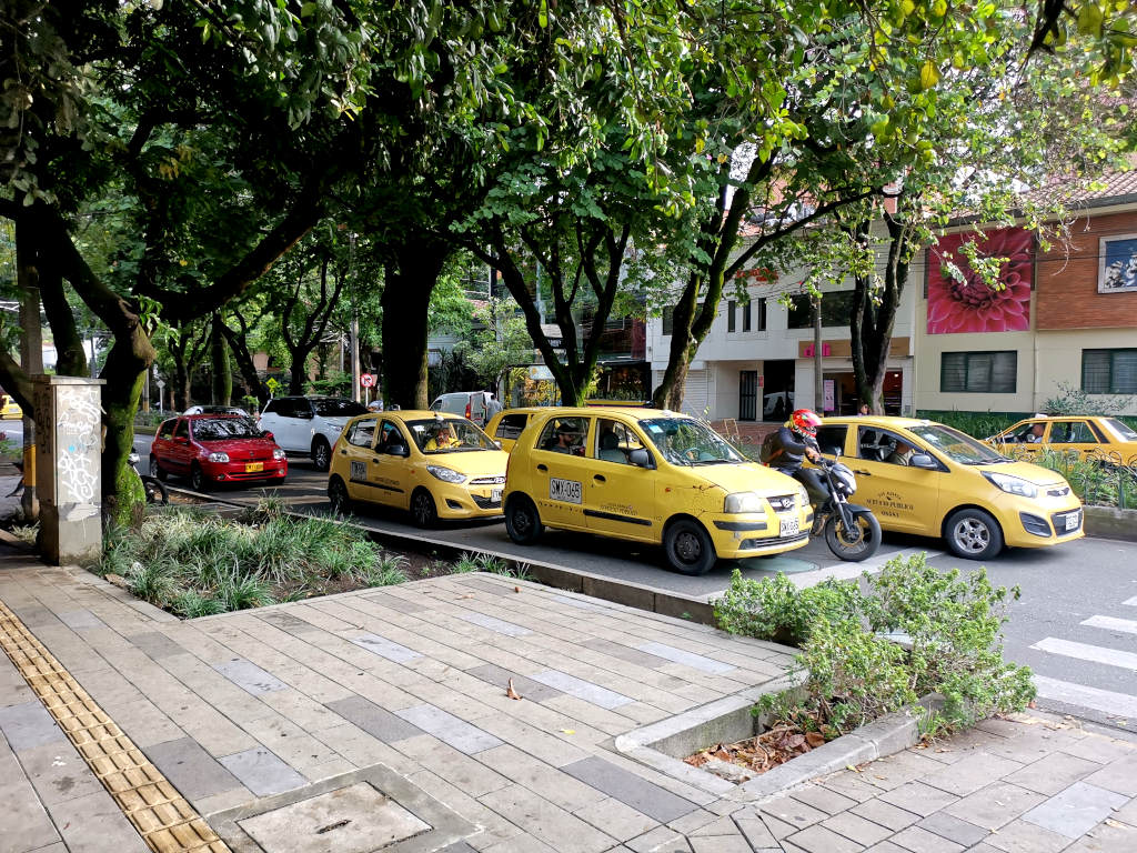 A group of four yellow taxis on the street in Medellin