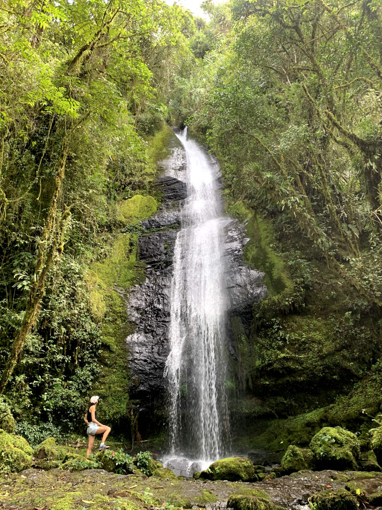 A woman looking up at the dragon falls which are located near Jardin Colombia