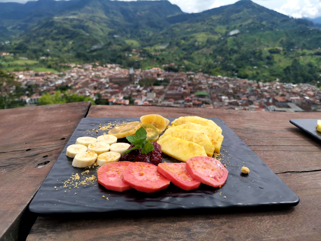 A plate of fruit on a table at the Cristo Rey restaurant with an amazing view of Jardin in Colombia