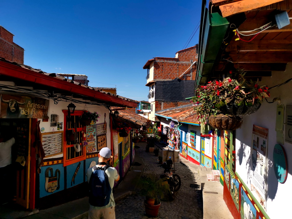 A man taking photographs in Guatapes colorful streets