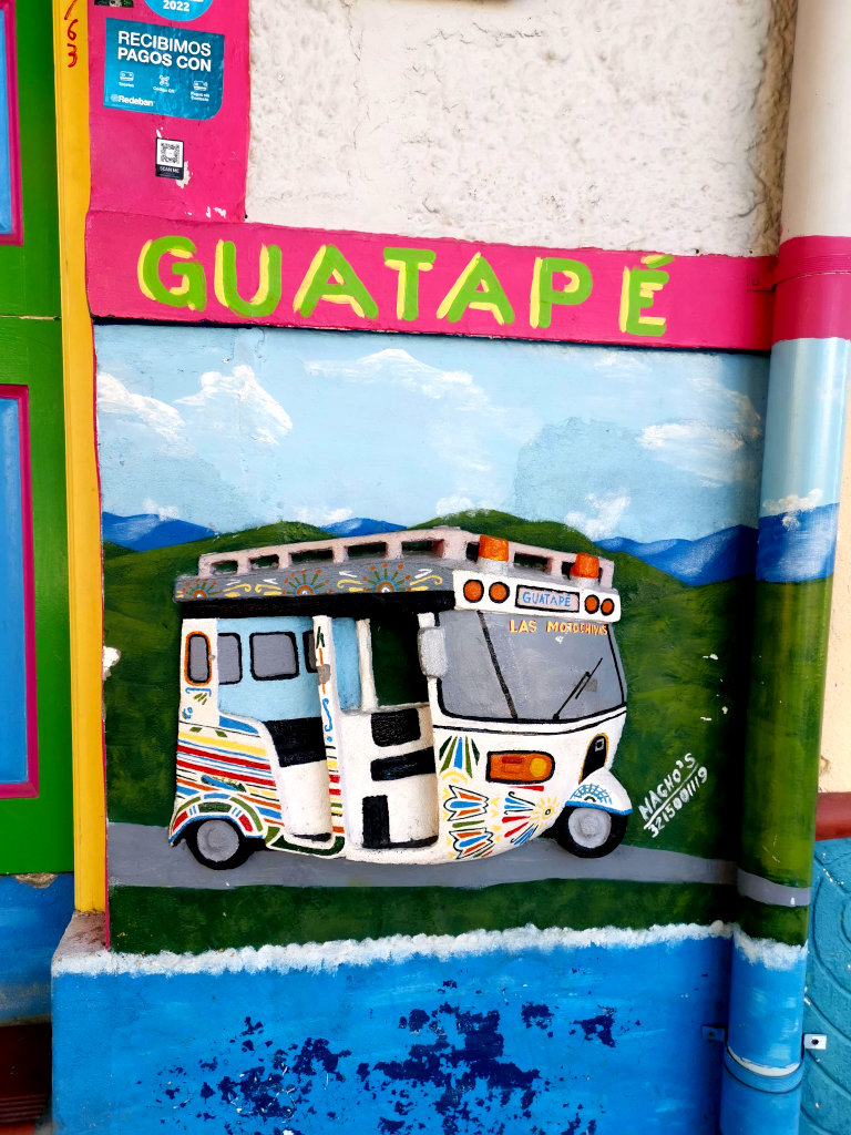 A piece of art on a wall showing a tuk tuk one of the best things to do in Guatape
