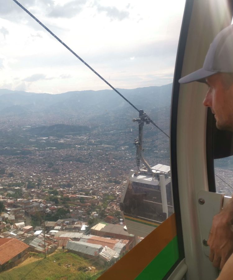 A man looking outside a cable car, the best way how to get to Parque Arvi