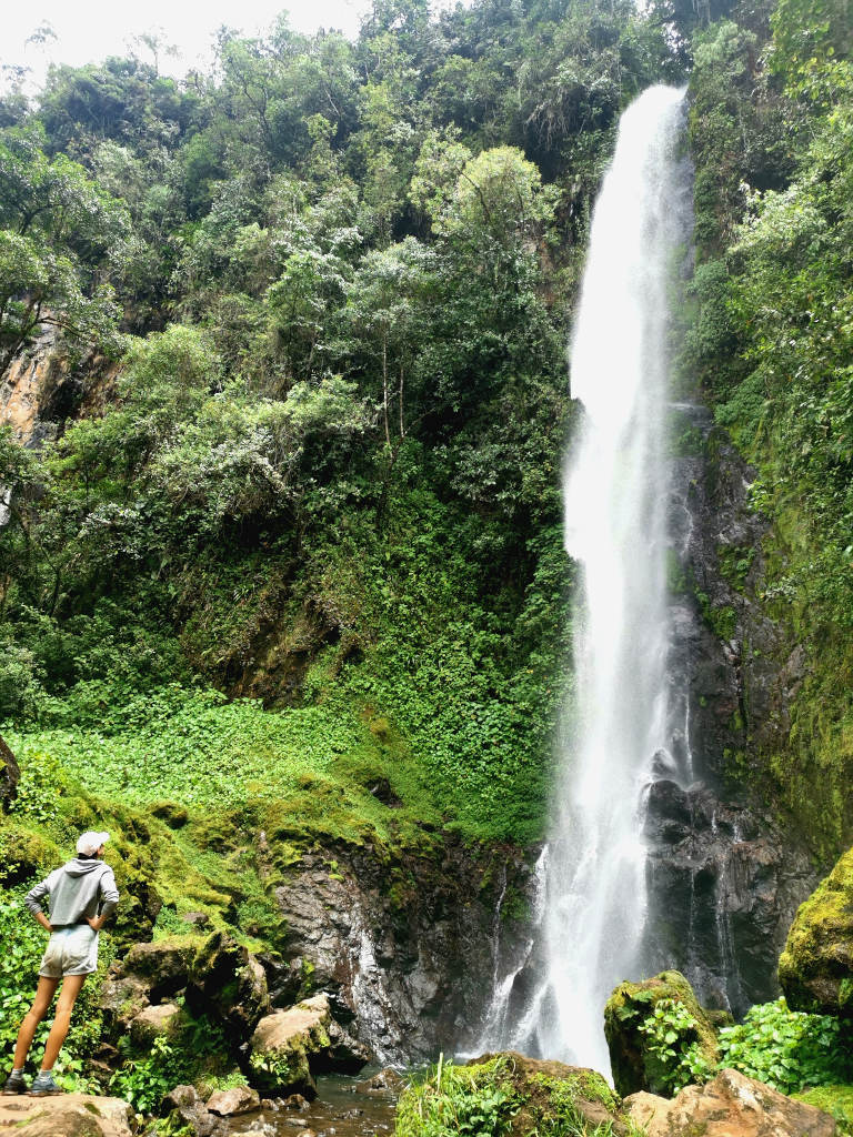A woman looking up at the Salto del Angel waterfall near Jardin Colombia