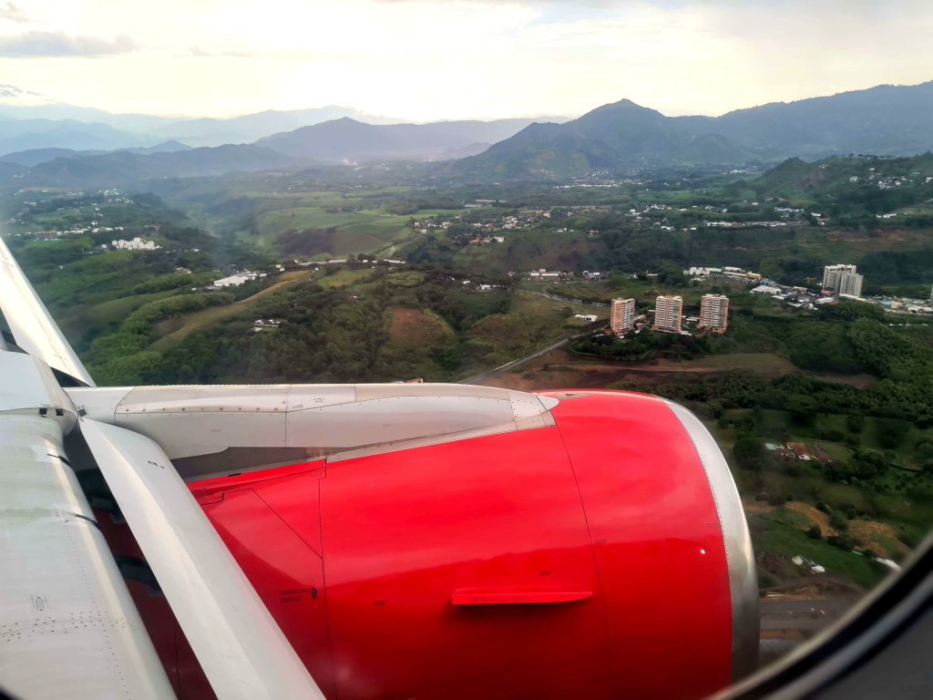 View out of an airplane overlooking green hills and Pereira