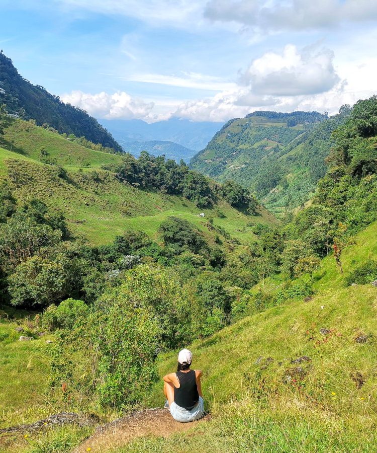 A woman overlooking a green valley on the best hikes in Jardin, Colombia