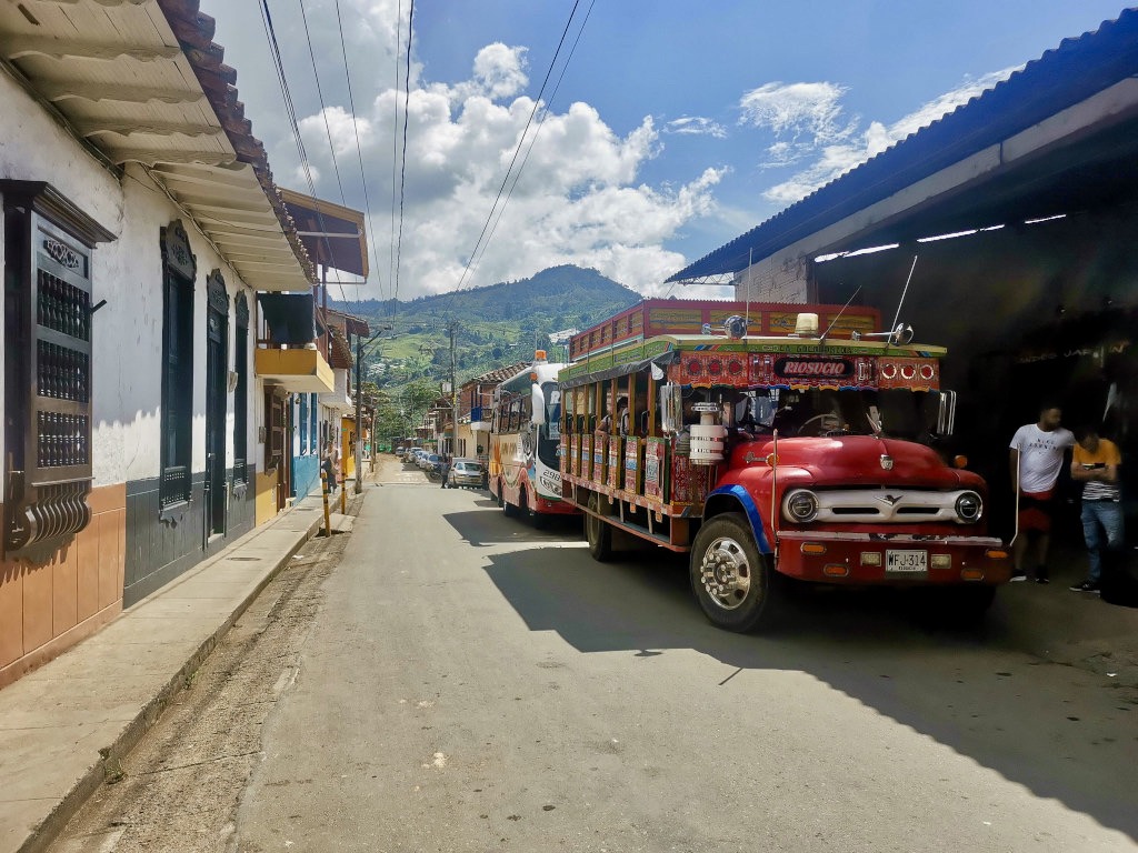 A local Colombian bus called a Chiva parked on the side of the road which is one of the best ways how to get to Salento