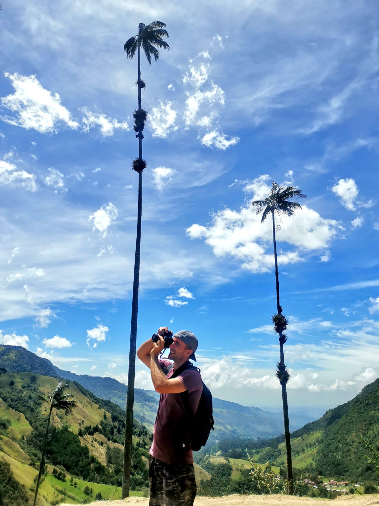 A man taking a photograph of the famous wax palms in Colombia's coffee region