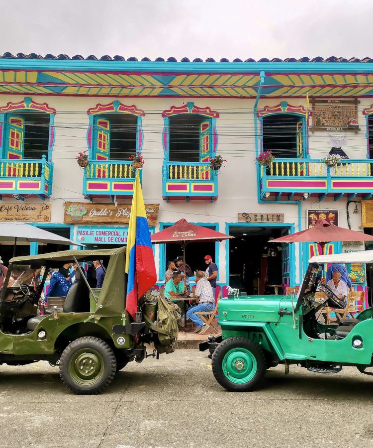 Colorful jeeps parked in front of colorful houses in Filandia - they are the best way to get from Salento to Filandia