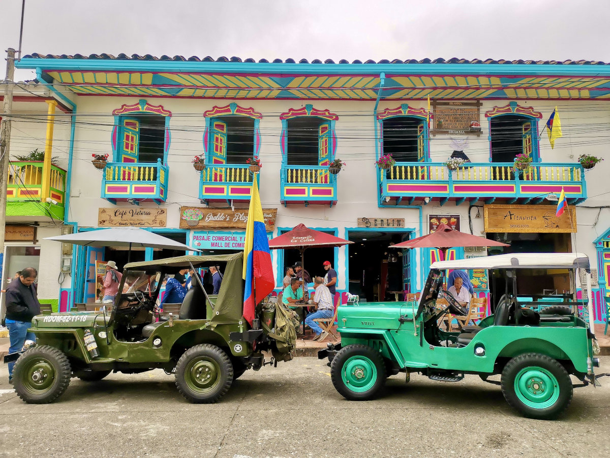 Colorful jeeps parked in front of colorful houses in Filandia - they are the best way to get from Salento to Filandia