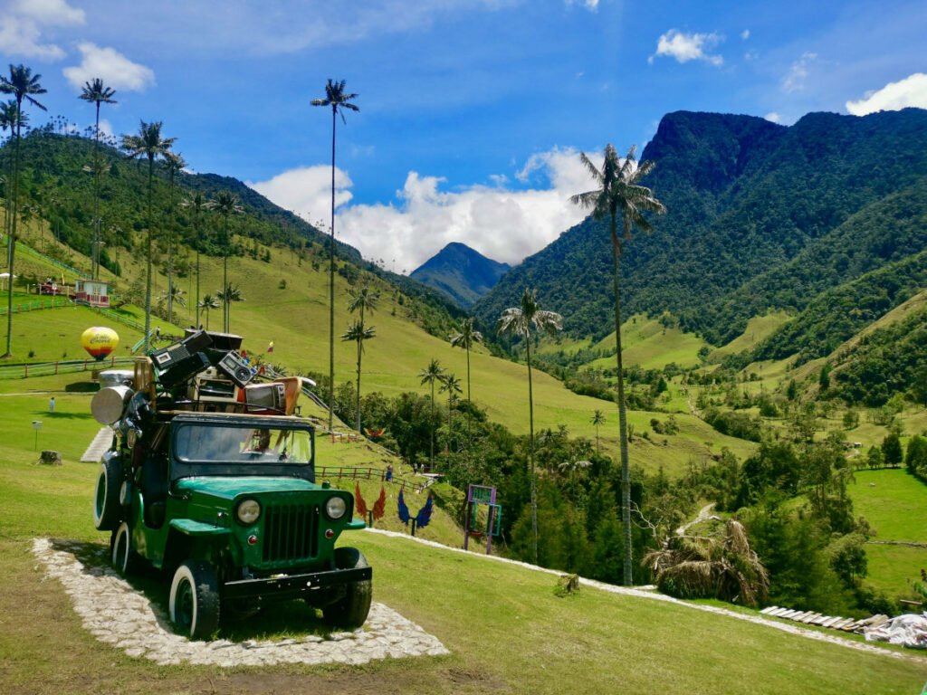 A green jeep ina field to be used for photos by tourists in the cocora valley one of the key attractions when choosing between Salento or Jardin
