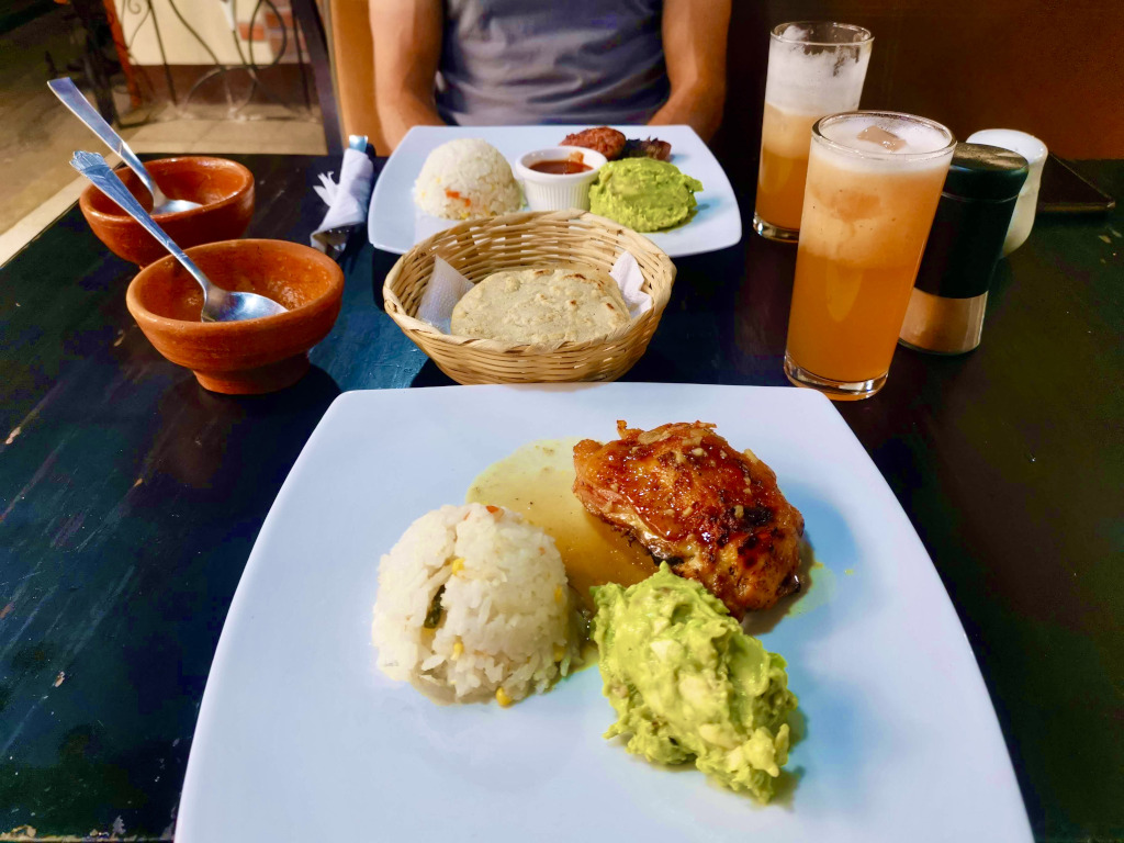 A plate of food with guacamole and a piece of meat at restaurante El Punto some of the best cheap eats in Antigua