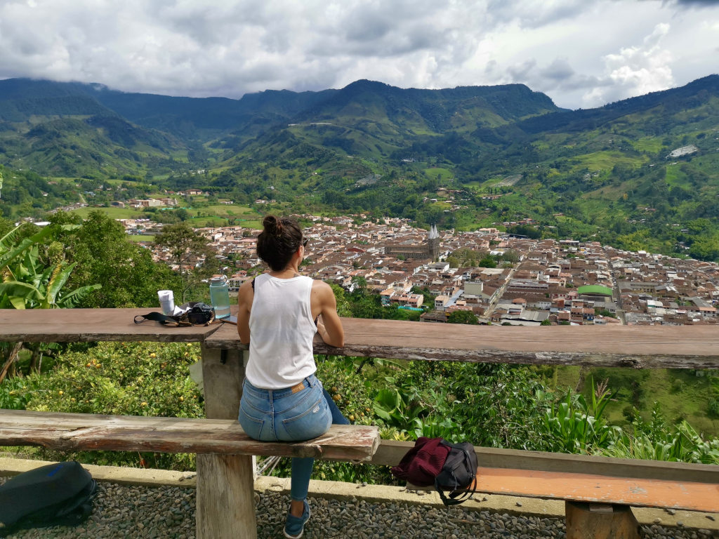A woman sitting at a table at a restaurant overlooking Jardin Colombia