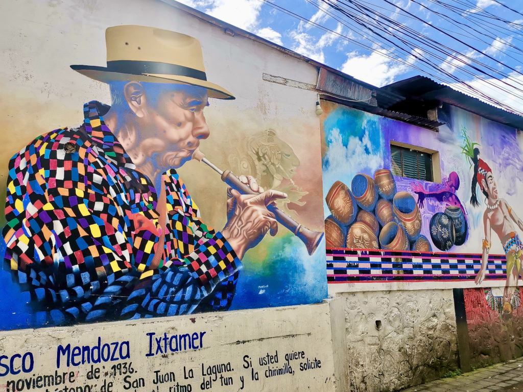 Some colorful street art in San Juan La Laguna of a man playing an instrument while wearing a colorful shirt