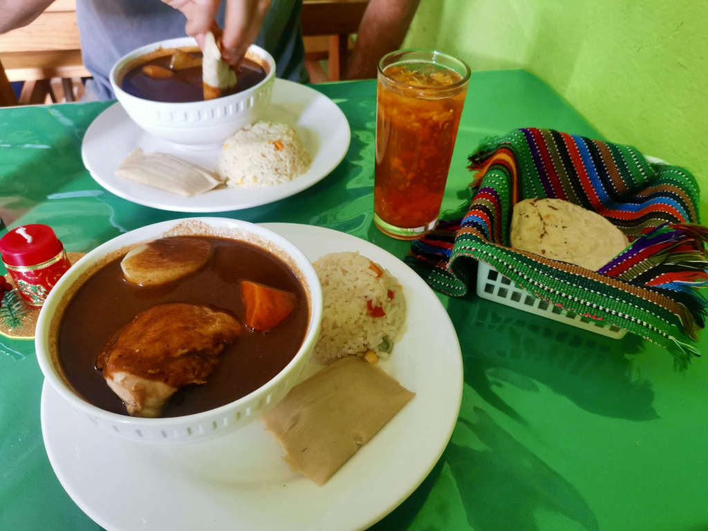 Two bowls of Pepian on a table with a green table cloth at a restaurant called Tierra Linda in Guatemala