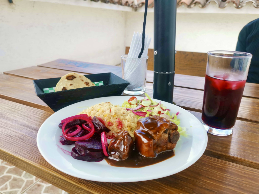 A meal from Urbano in Antigua Guatemala consisting of bbq ribs, beetroot, rice and a jamaica juice