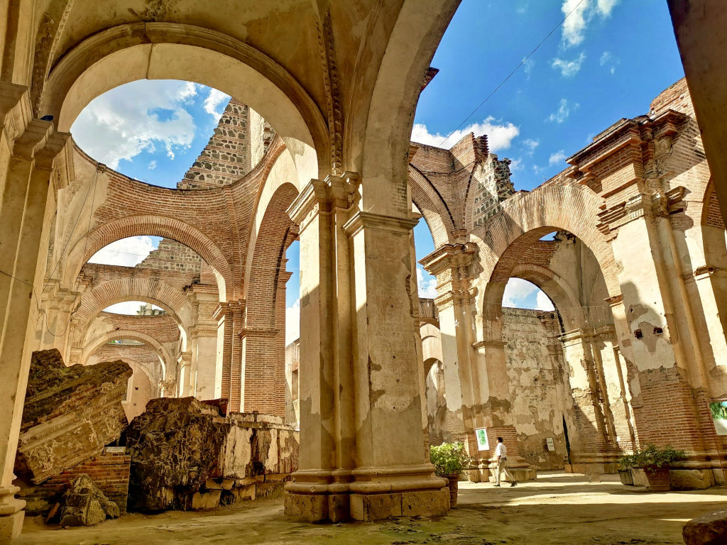 A man walking through the ruins of an old church one of the best cheap things to do in Antigua Guatemala