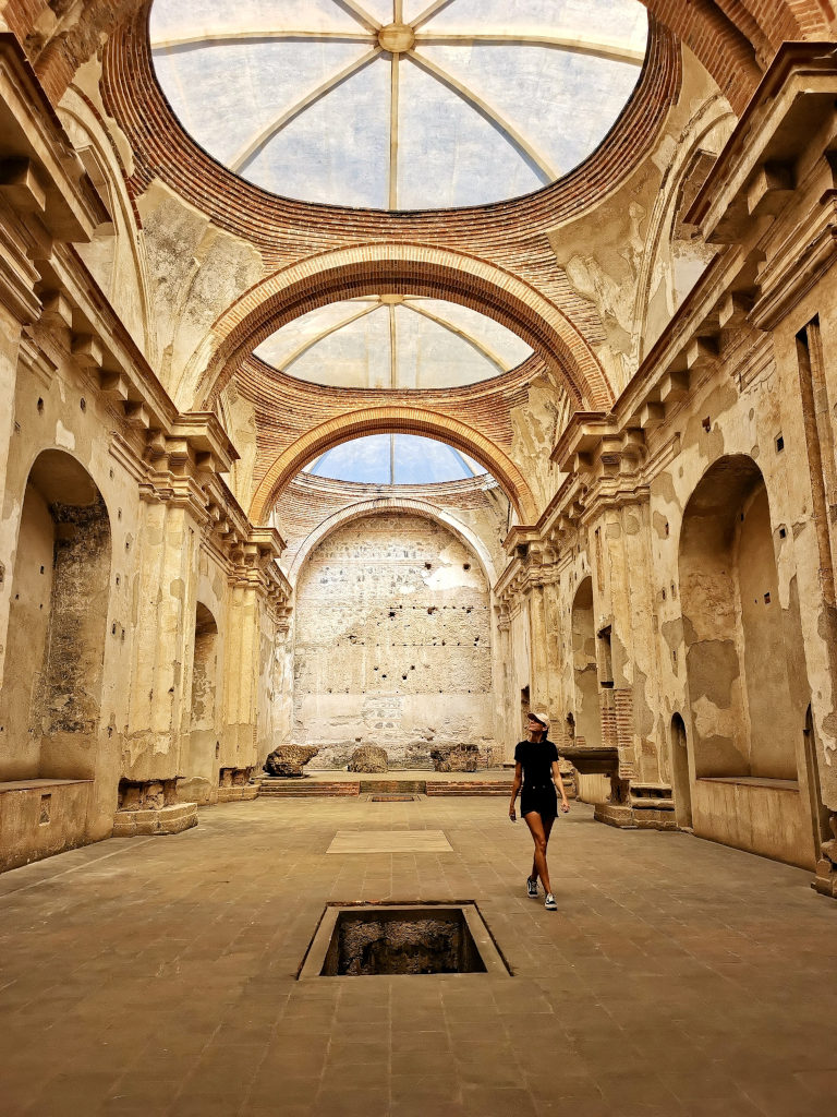 A woman walking through the abandonded interior of a church in Antigua Guatemala