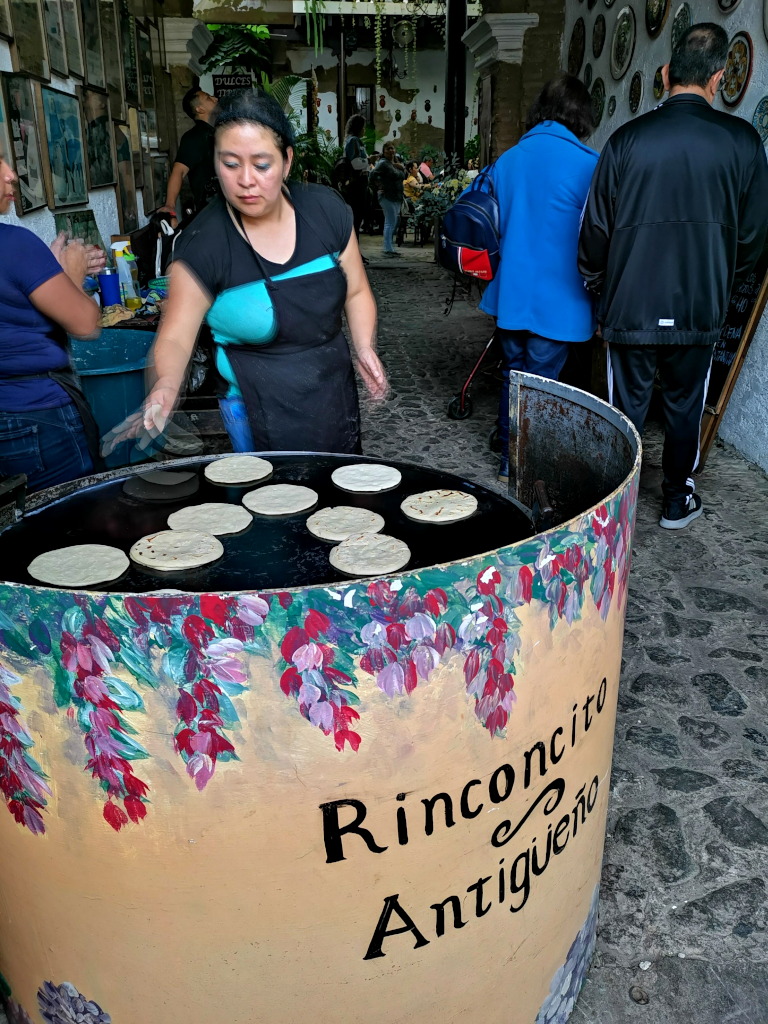 A Guatemala lady making tortillas at a restaurant entrance