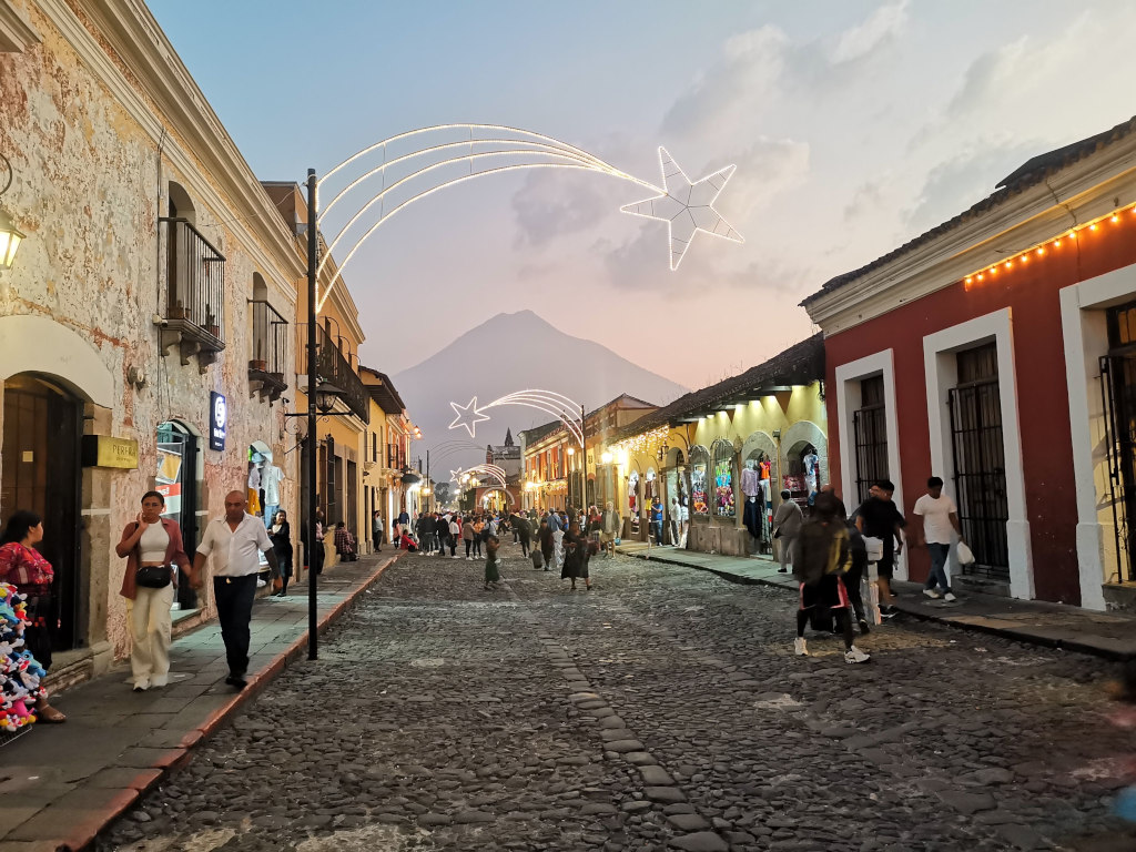 People walking down the main street of Antigua Guatemala on New Years Eve at sunset 