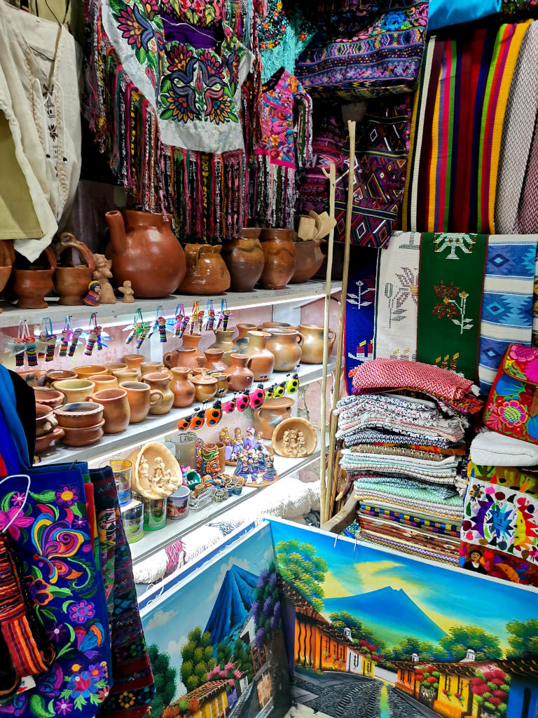 A stand in a market selling colorful Guatemalan clothing