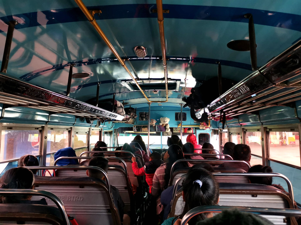 A group of people sitting inside a Chicken bus one of the cheapeset ways how to get from Guatemala City to Lake Atitlan