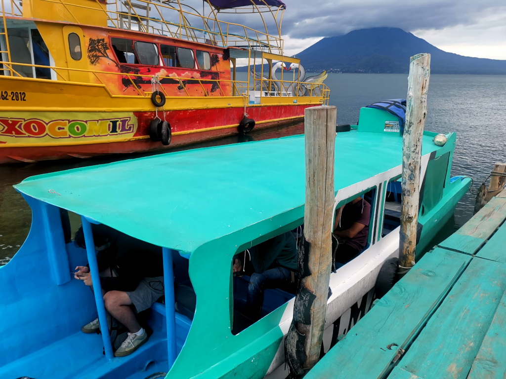 A blue boat with passengers departing from Panajachel to San Juan La Laguna