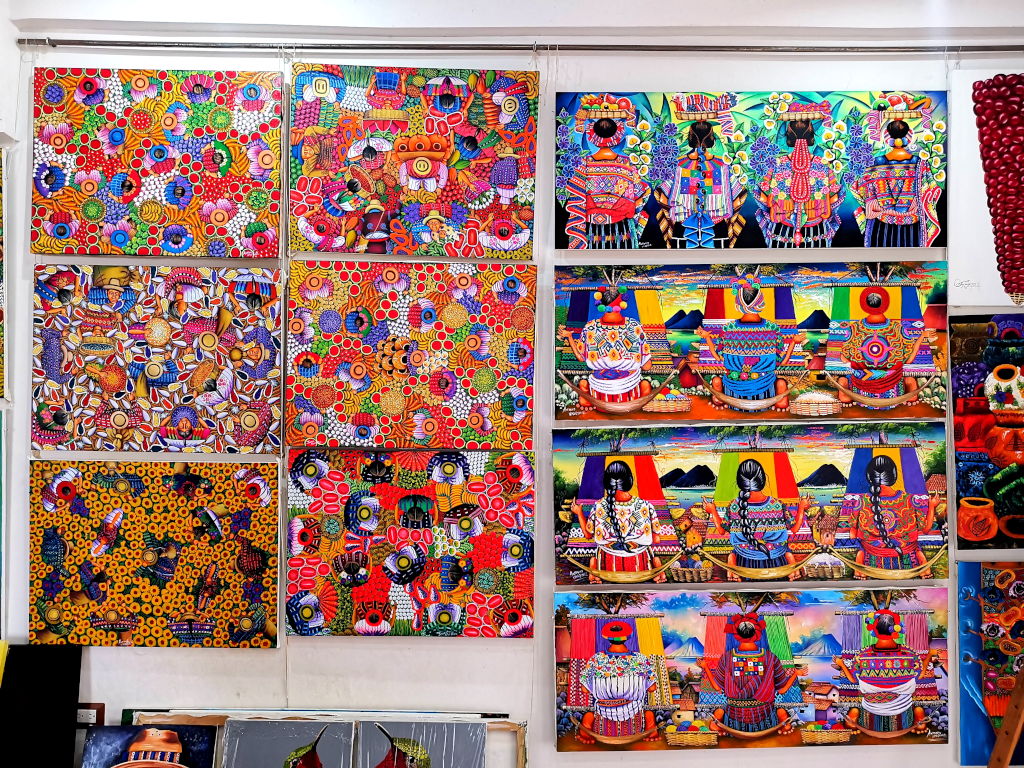 Bright colorful paintings on a wall showing local life in San Juan La Laguna