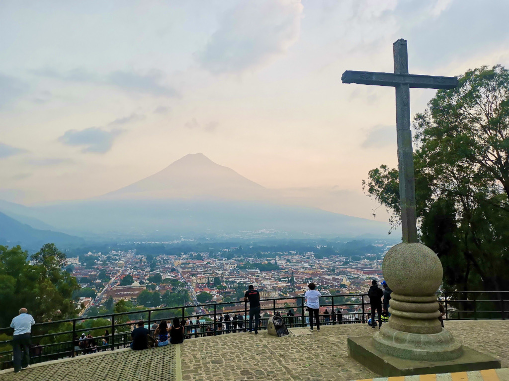 A volcano surrounded by thin cloud at sunset in Antigua Guatemala viewed from the Hill of the Cross viewpoint