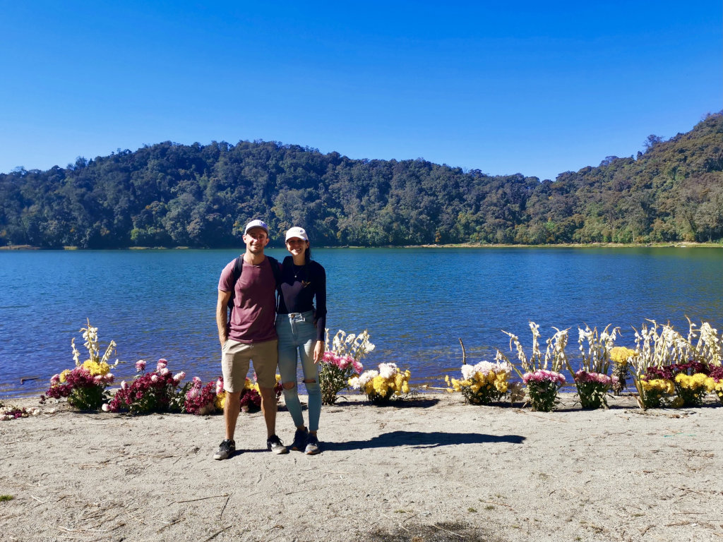 A couple standing with their arms around each other in front of Lago Chicabal one of the top reasons to go from Guatemala City to Quetzaltenango (Xela)