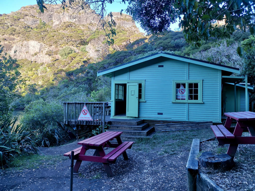 The outside of Lane Cove Hut with Duke's Nose in the back