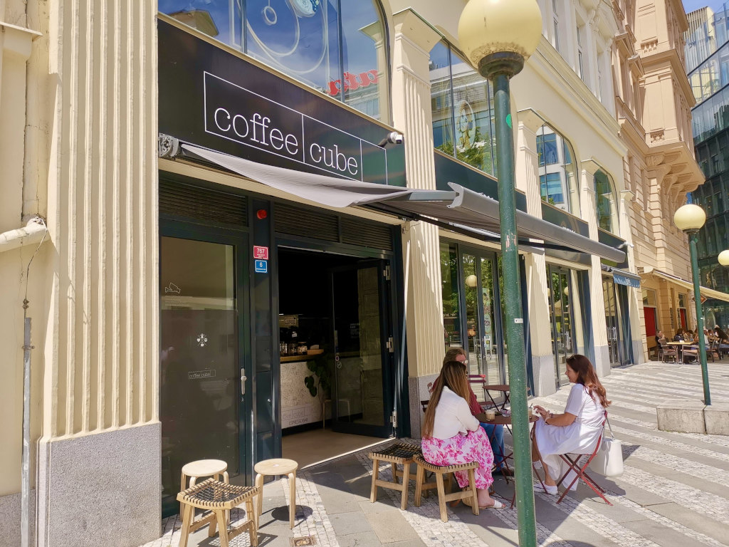 People sitting outside of Coffee Cube Black, one of the best places for coffee in Prague