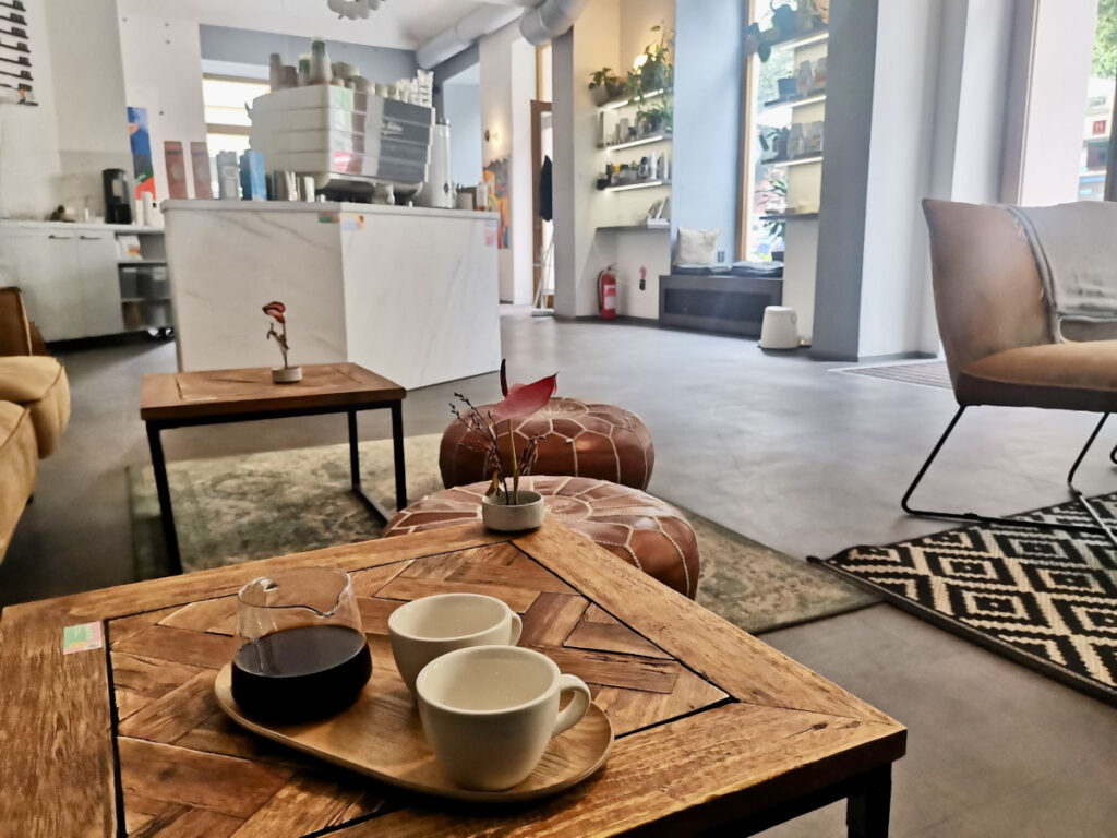 Two coffee cups sitting next to a small jug of coffee at a modern beautifully decorated cagr