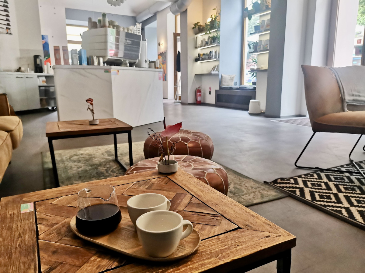 A set of two empty coffee cups and a jar with black coffee sitting on a wooden table in one of Prague's best specialty cafes