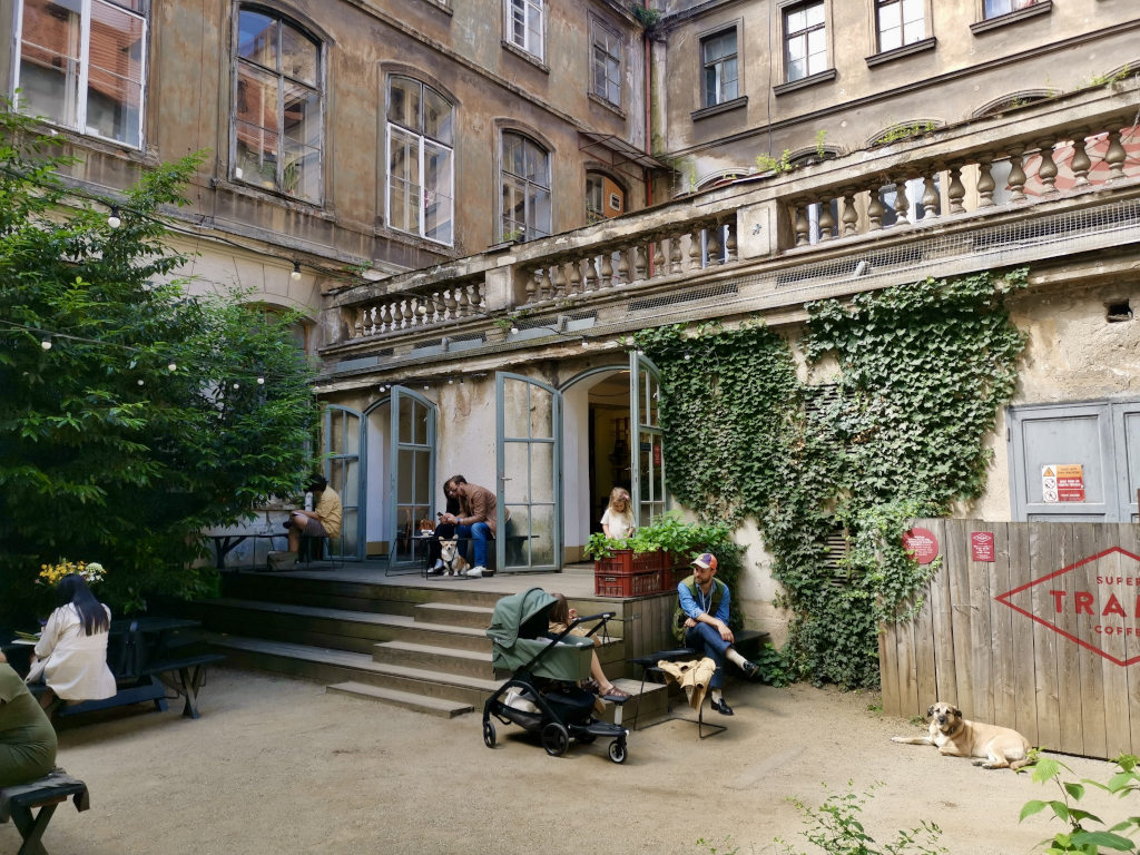 People sitting in the courtyard of Super Tramp Cafe one of the best cafes in Prague