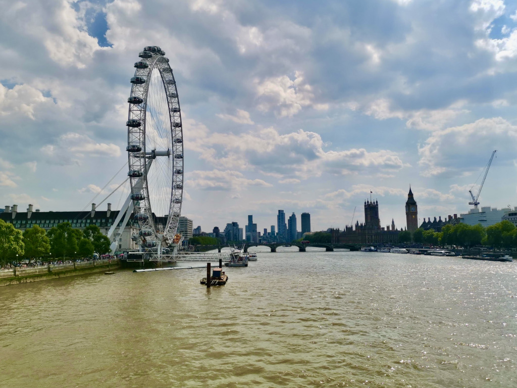 The river thames in london with the london eye on one side of the river and big ben on the other side of the river